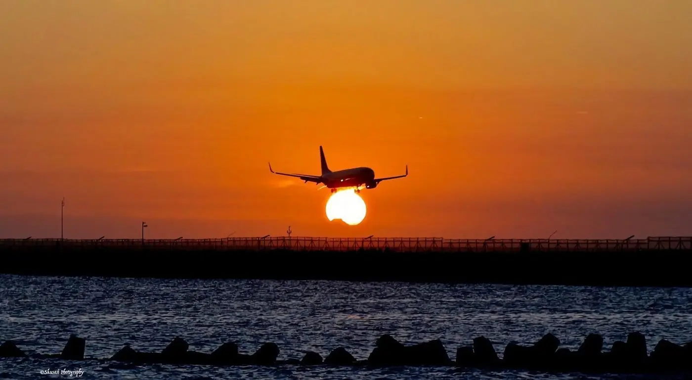 sunset view with a plane landing