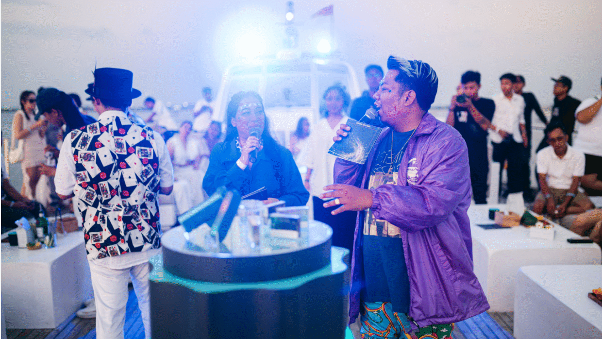 Performers in costume entertaining guests at a deck party under bright lights