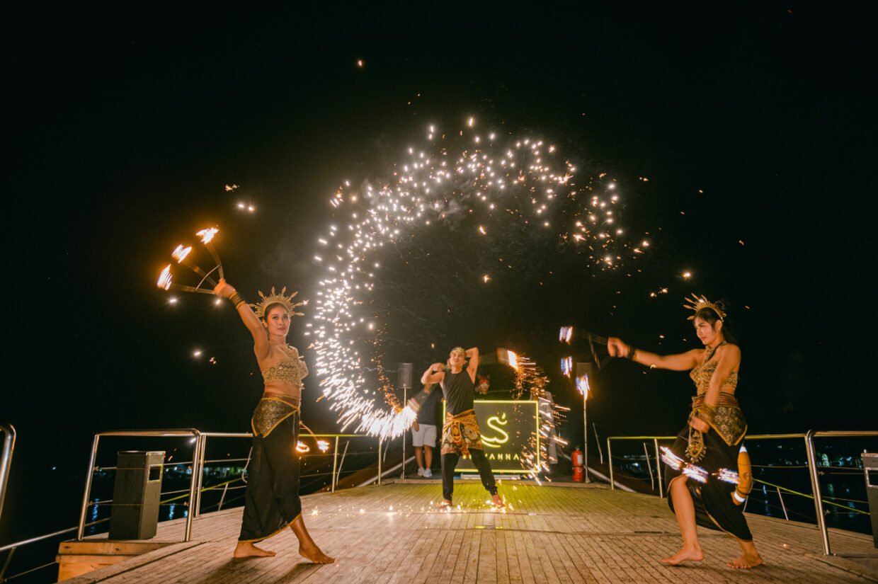 Balinese fire dancers performing with sparklers on deck at night before the Shivanna sign