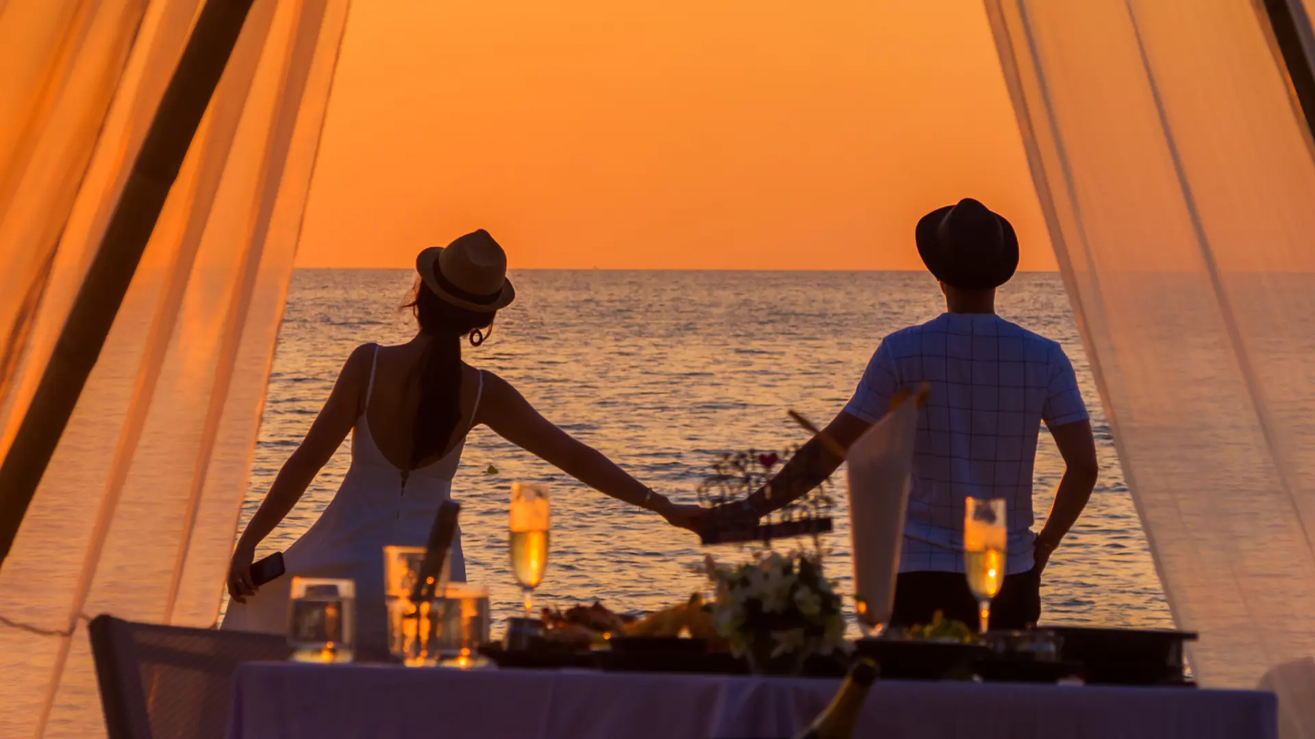 a couple holding hand while watching beach together