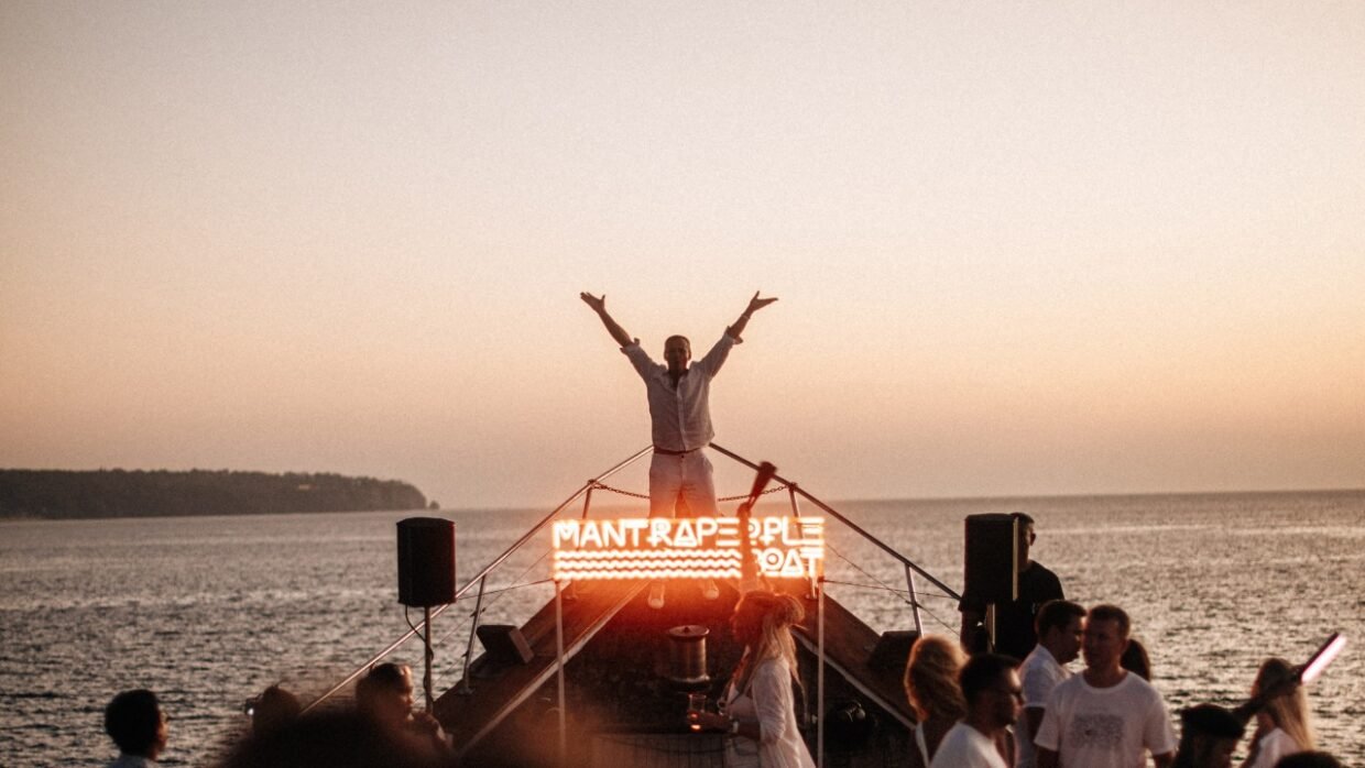 Sunset boat party on the ocean with guests enjoying the evening, cinematic view, Shivanna.