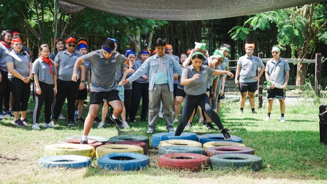 Team building participants crossing colorful tire obstacles during an outdoor challenge