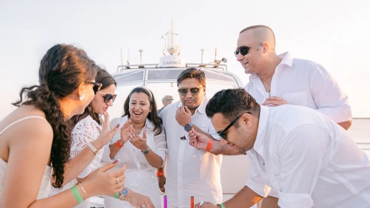 Group of people celebrating on a boat of Shivanna at sunset.