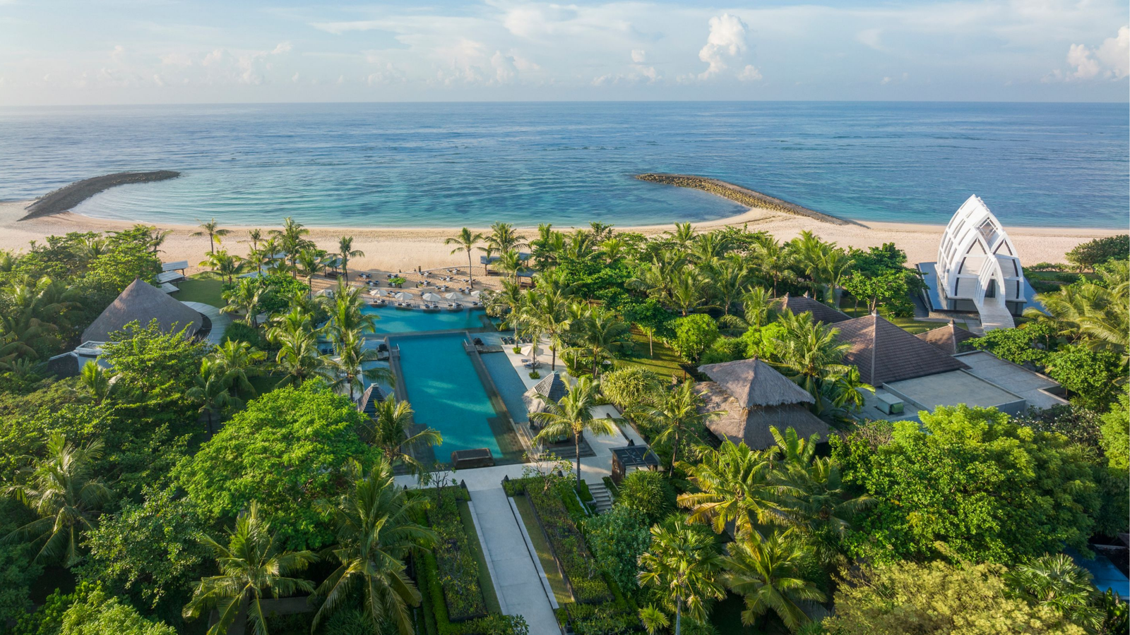 Aerial view of a tropical beachfront resort with pools and ocean views